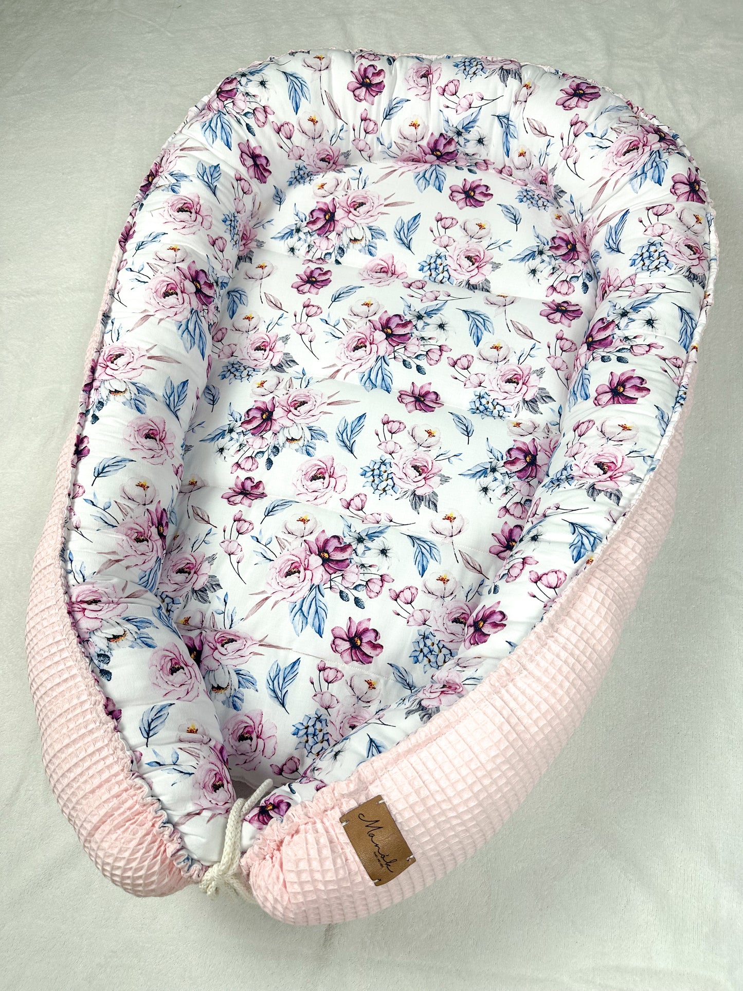 as Nestchen ist aus atmungsaktiven Materialien gefertigt und hat eine gepolsterte Umrandung, die das Baby sanft umschließt und vor äußeren Störungen schützt. Ideal für den Einsatz im Kinderbett oder auf der Couch, um dem Baby einen ruhigen und geschützten Schlafplatz zu bieten.