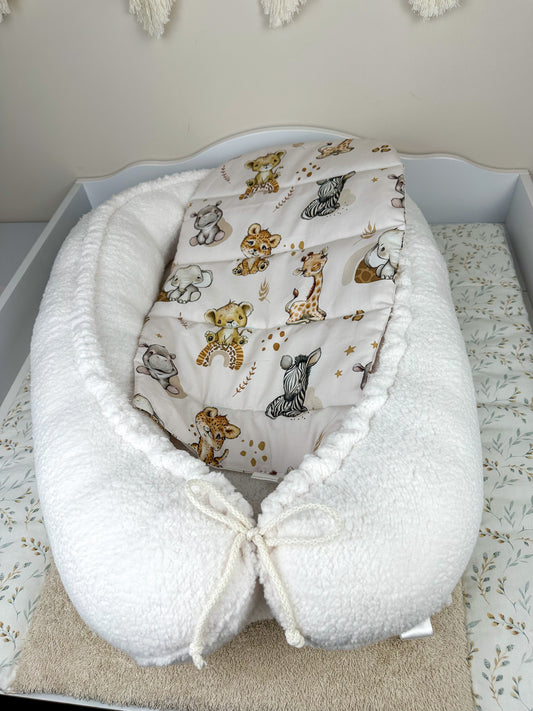 as Nestchen ist aus atmungsaktiven Materialien gefertigt und hat eine gepolsterte Umrandung, die das Baby sanft umschließt und vor äußeren Störungen schützt. Ideal für den Einsatz im Kinderbett oder auf der Couch, um dem Baby einen ruhigen und geschützten Schlafplatz zu bieten.