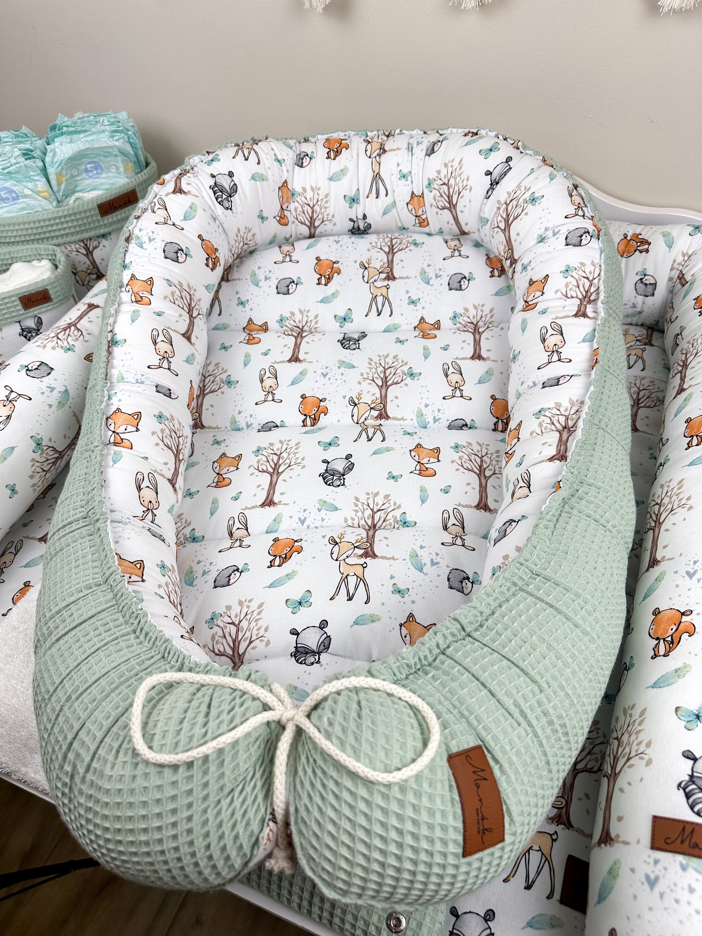 as Nestchen ist aus atmungsaktiven Materialien gefertigt und hat eine gepolsterte Umrandung, die das Baby sanft umschließt und vor äußeren Störungen schützt. Ideal für den Einsatz im Kinderbett oder auf der Couch, um dem Baby einen ruhigen und geschützten Schlafplatz zu bieten.