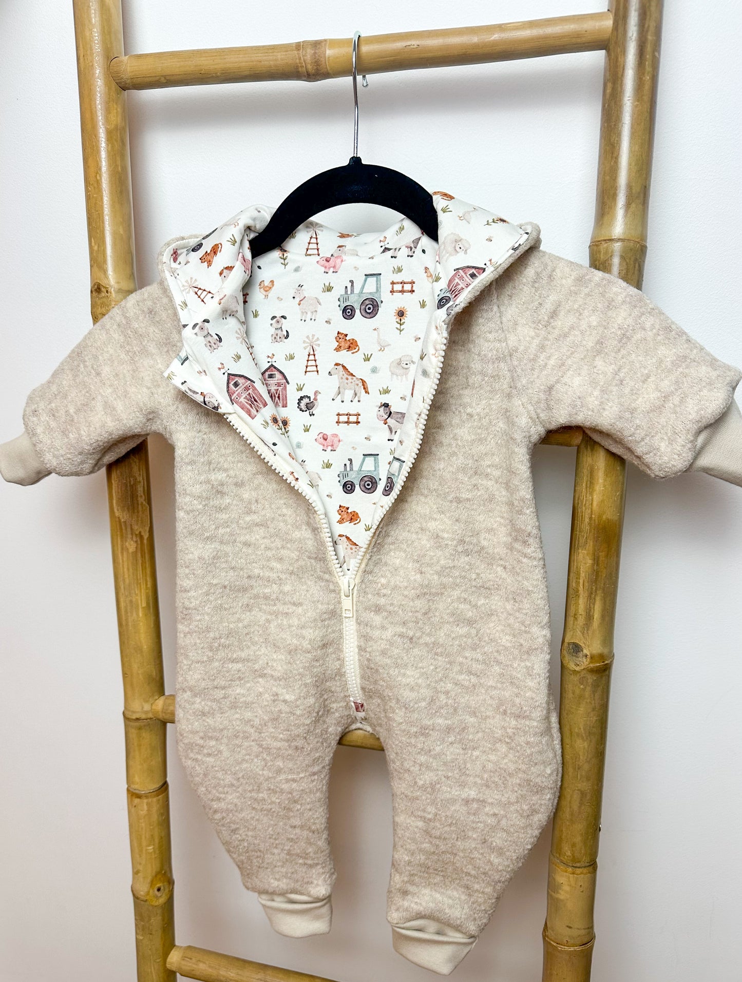Ein Walkoverall für Babys ist ein warmer und bequemer Anzug, der aus Walkstoff gefertigt ist. Dieser Stoff ist besonders gut geeignet, um die Kleinen warm zu halten, da er atmungsaktiv und gleichzeitig isolierend ist. Walkoveralls sind oft handgemacht, was bedeutet, dass sie mit viel Liebe und Sorgfalt gefertigt werden. Sie sind ideal für kalte Tage, da sie den ganzen Körper des Babys warmhalten und gleichzeitig Bewegungsfreiheit bieten. Viele Modelle haben praktische Details wie eine Kapuze, um den Kopf de