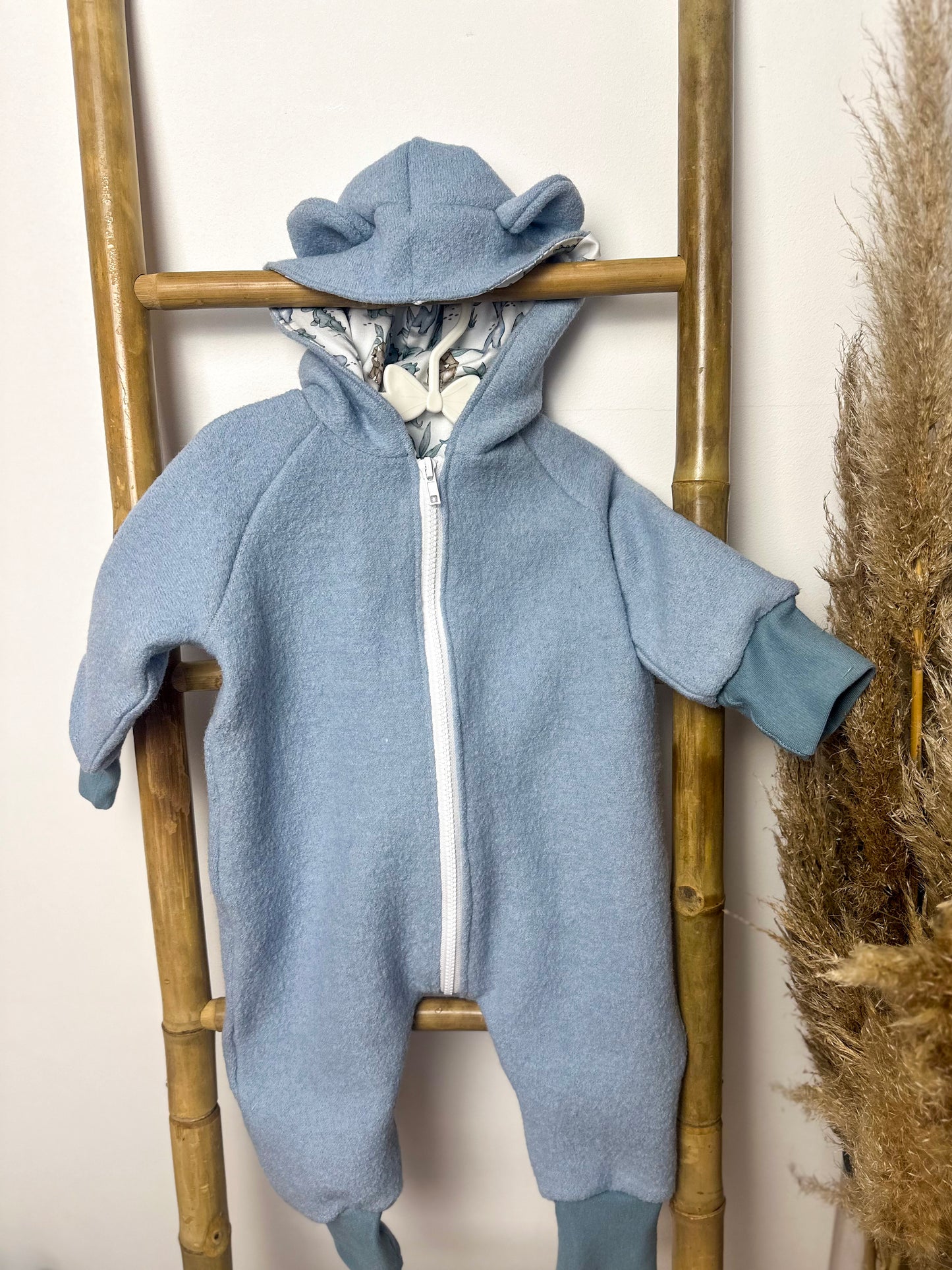 Ein Walkoverall für Babys ist ein warmer und bequemer Anzug, der aus Walkstoff gefertigt ist. Dieser Stoff ist besonders gut geeignet, um die Kleinen warm zu halten, da er atmungsaktiv und gleichzeitig isolierend ist. Walkoveralls sind oft handgemacht, was bedeutet, dass sie mit viel Liebe und Sorgfalt gefertigt werden. Sie sind ideal für kalte Tage, da sie den ganzen Körper des Babys warmhalten und gleichzeitig Bewegungsfreiheit bieten. Viele Modelle haben praktische Details wie eine Kapuze, um den Kopf de