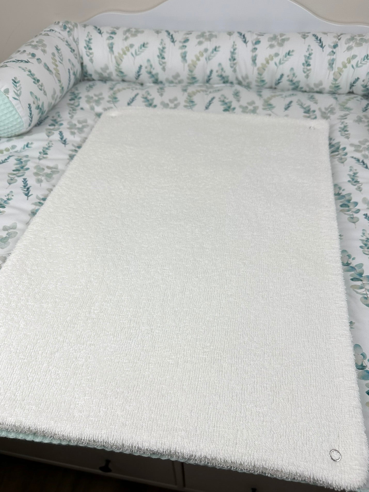 Die Auflage ist in sanften Farben gestaltet und bietet eine bequeme und hygienische Oberfläche für das Wickeln von Babys. Der Wechsel erfolgt schnell und einfach, was Eltern eine stressfreie Wickelerfahrung ermöglicht.