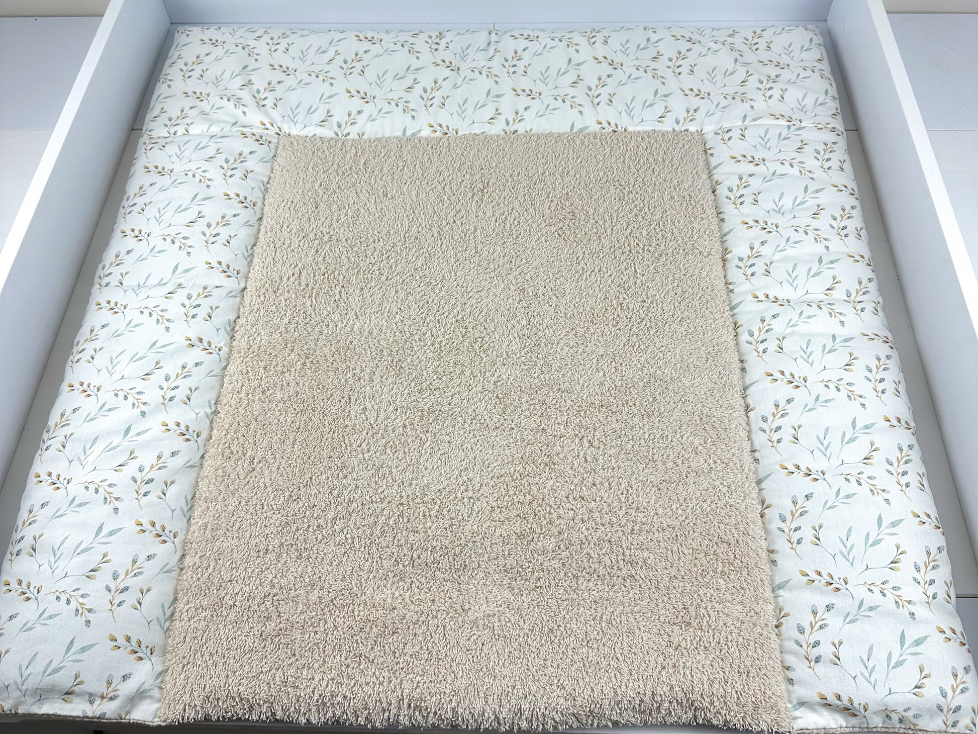 Eine stilvolle Wickeltischauflage, die durch ihre vielfältigen Designs besticht. Die Auflage ist aus hochwertigem Frottee gefertigt, das sowohl weich als auch strapazierfähig ist. Sie bietet eine komfortable und hygienische Fläche für das Wickeln von Babys und fügt sich harmonisch in moderne Kinderzimmer ein.