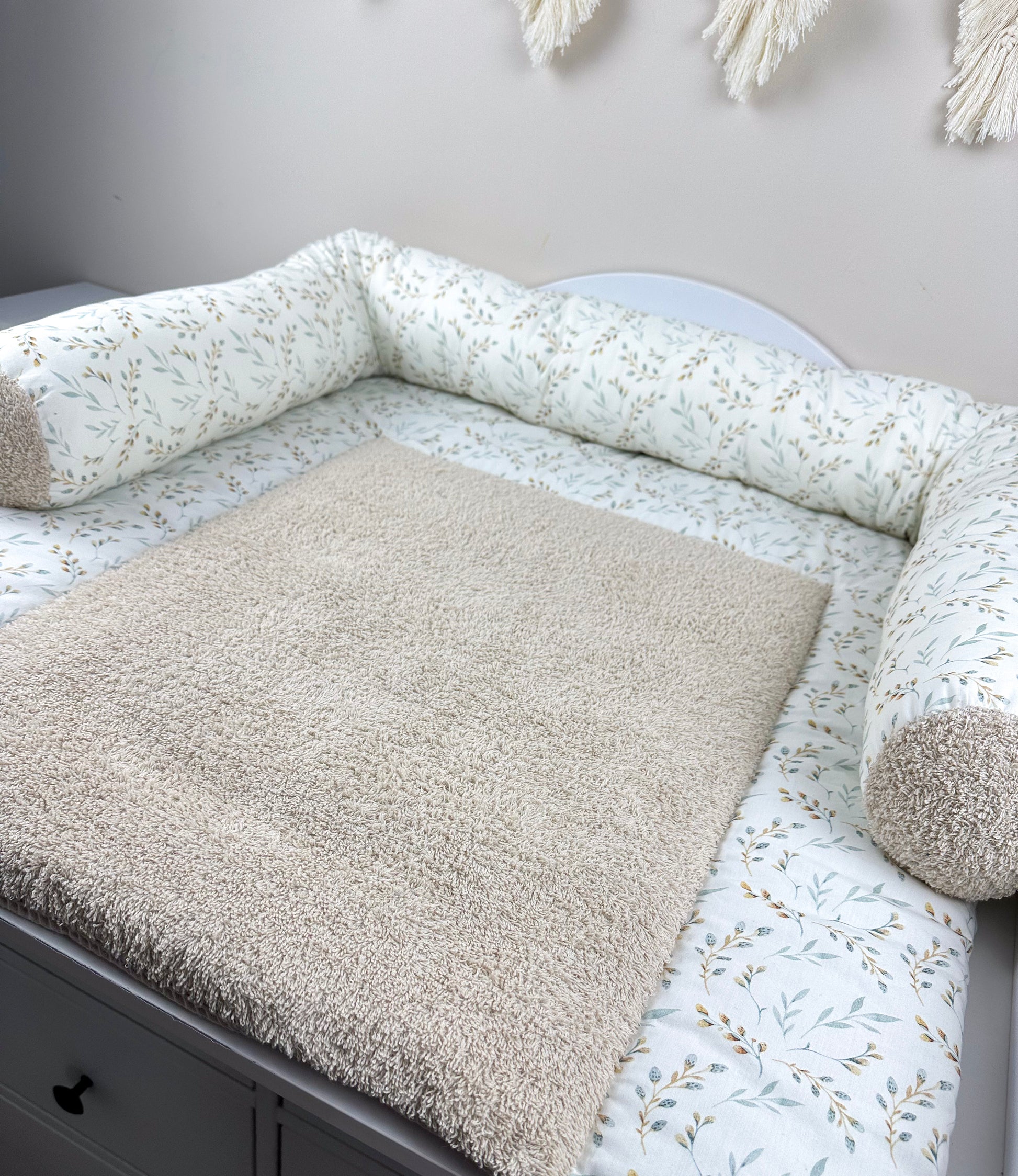 Eine stilvolle Wickeltischauflage, die durch ihre vielfältigen Designs besticht. Die Auflage ist aus hochwertigem Frottee gefertigt, das sowohl weich als auch strapazierfähig ist. Sie bietet eine komfortable und hygienische Fläche für das Wickeln von Babys und fügt sich harmonisch in moderne Kinderzimmer ein.