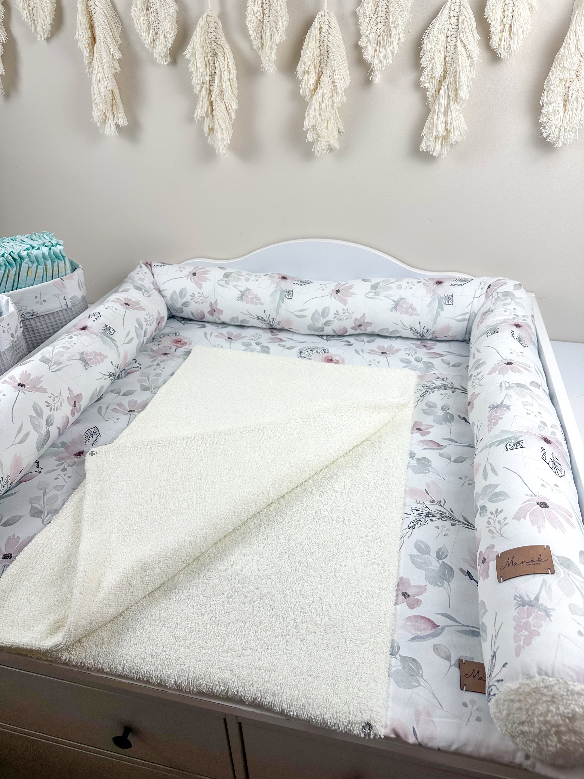 Eine stilvolle Wickeltischauflage, die durch ihre vielfältigen Designs besticht. Die Auflage ist aus hochwertigem Frottee gefertigt, das sowohl weich als auch strapazierfähig ist. Sie bietet eine komfortable und hygienische Fläche für das Wickeln von Babys und fügt sich harmonisch in moderne Kinderzimmer ein.