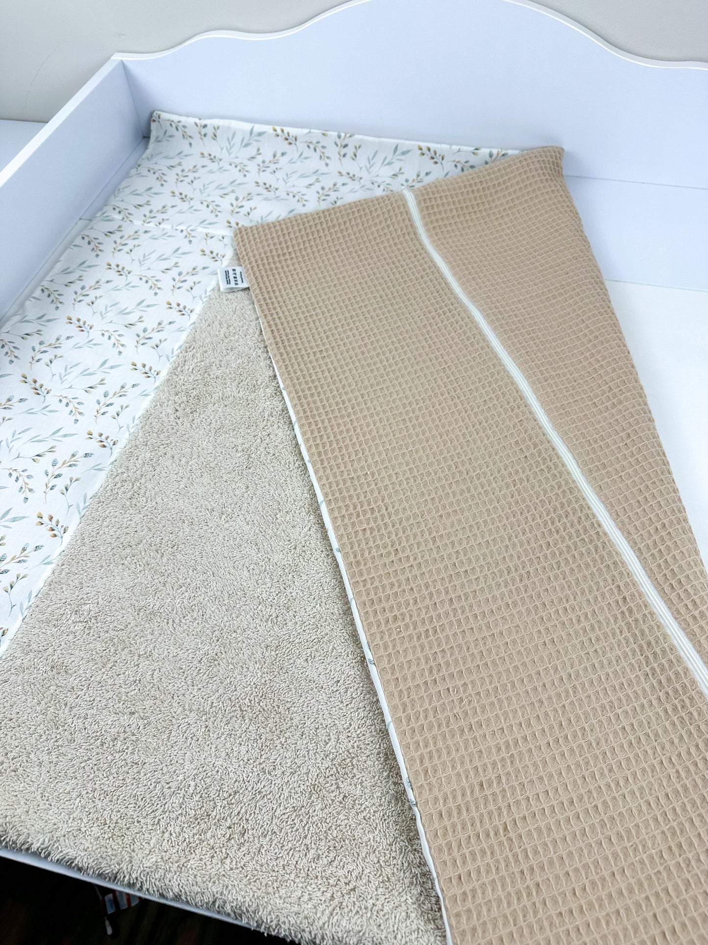 Set aus einem weichen Wickelauflagenbezug und einer passenden Bettschlange, beide in sanften Farben und liebevollen Mustern gestaltet. Der Wickelauflagenbezug sorgt für Komfort und Hygiene beim Wickeln, während die Bettschlange als dekoratives Element und Schutz für das Baby im Bett dient. Ideal für eine gemütliche und sichere Umgebung im Kinderzimmer.