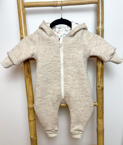 Ein Walkoverall für Babys ist ein warmer und bequemer Anzug, der aus Walkstoff gefertigt ist. Dieser Stoff ist besonders gut geeignet, um die Kleinen warm zu halten, da er atmungsaktiv und gleichzeitig isolierend ist. Walkoveralls sind oft handgemacht, was bedeutet, dass sie mit viel Liebe und Sorgfalt gefertigt werden. Sie sind ideal für kalte Tage, da sie den ganzen Körper des Babys warmhalten und gleichzeitig Bewegungsfreiheit bieten. Viele Modelle haben praktische Details wie eine Kapuze, um den Kopf de