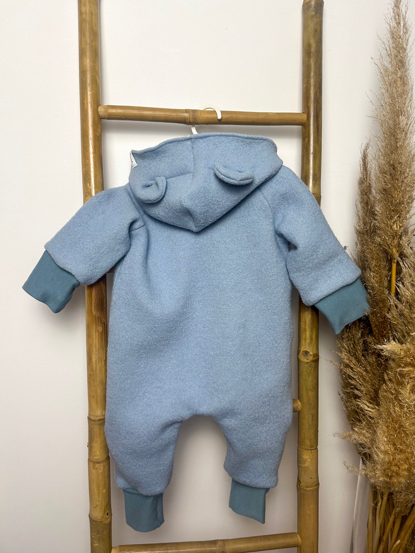 Ein Walkoverall für Babys ist ein warmer und bequemer Anzug, der aus Walkstoff gefertigt ist. Dieser Stoff ist besonders gut geeignet, um die Kleinen warm zu halten, da er atmungsaktiv und gleichzeitig isolierend ist. Walkoveralls sind oft handgemacht, was bedeutet, dass sie mit viel Liebe und Sorgfalt gefertigt werden. Sie sind ideal für kalte Tage, da sie den ganzen Körper des Babys warmhalten und gleichzeitig Bewegungsfreiheit bieten. Viele Modelle haben praktische Details wie eine Kapuze, um den Kopf de